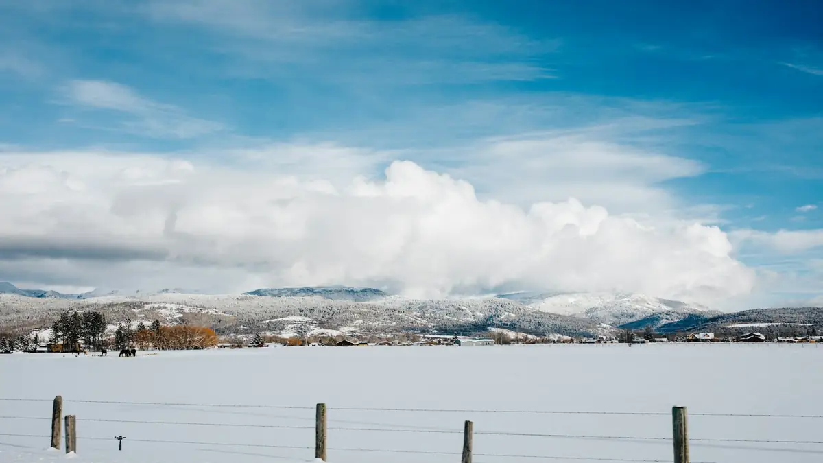 Snow-covered flat ground with a town and mountains in the distance - Leak Detection in North Caldwell
